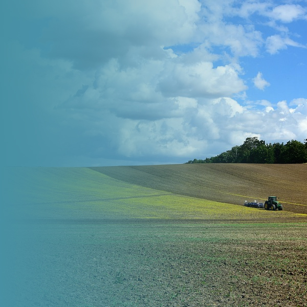 Tractor on farm land with ploughing equipment