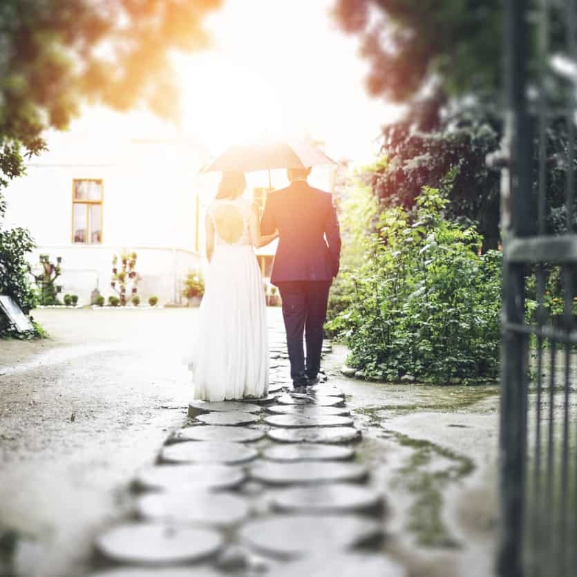 Couple on wedding day under umbrella