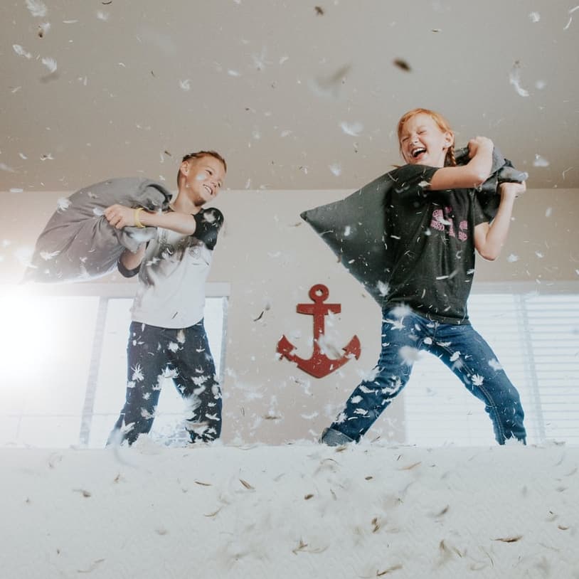 Two children having a pillow fight