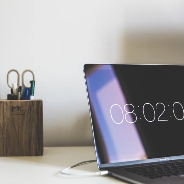 Laptop on a table showing the current time